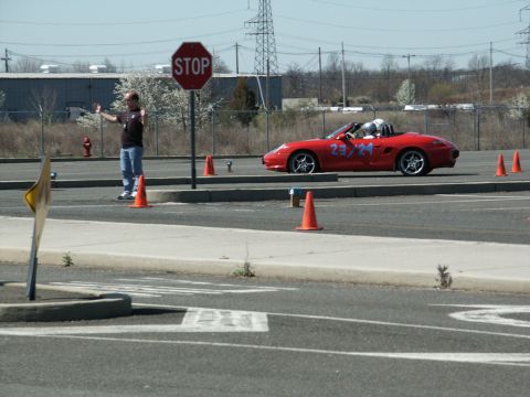 2001 Mercury Grand Marquis - A red convertible is participating in an autocross event, navigating a course marked by orange cones.