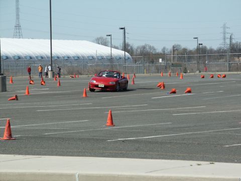 2001 Mercury Grand Marquis - A red convertible navigates an autocross course on a sunny day, with spectators in the background.