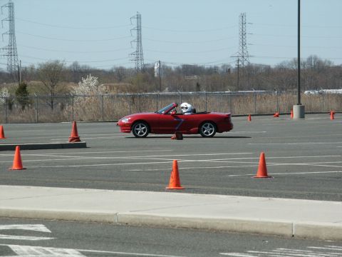 2001 Mercury Grand Marquis - A red convertible navigates an autocross course marked by orange cones under a clear sky.