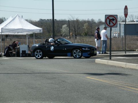 2001 Mercury Grand Marquis - A black convertible sports car with racing number 2 is parked near a tent and traffic signs.