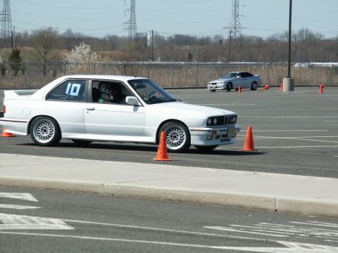 2001 Mercury Grand Marquis - White BMW E30 coupe at an autocross event, with another car visible in the background.