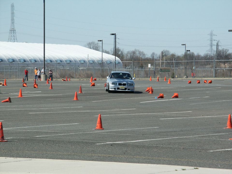 Silver sedan with a distinctive grille and front bumper navigating a cone course