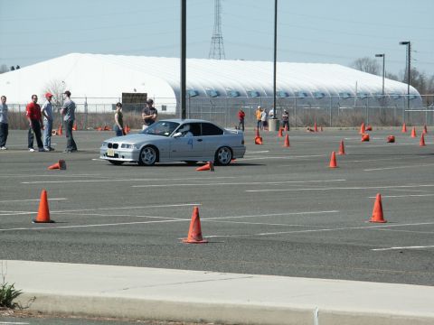 2001 Mercury Grand Marquis - Silver BMW E36 M3 navigates an autocross course marked by orange cones.