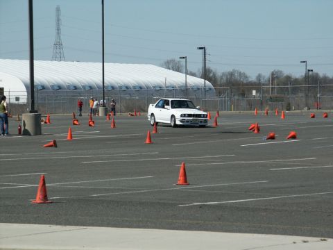 2001 Mercury Grand Marquis - A white BMW E30 M3 is seen during an autocross event on a paved lot.