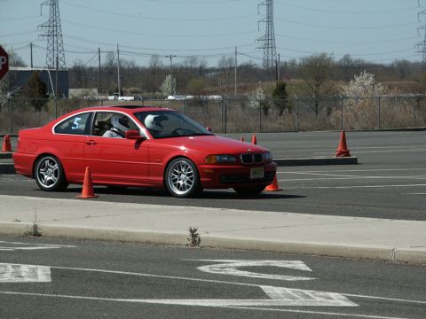 2001 Mercury Grand Marquis - Red BMW 3 Series coupe navigates a course marked by orange cones on a sunny day.