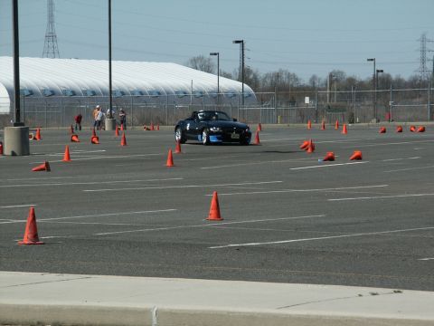 2001 Mercury Grand Marquis - A black BMW Z4 navigates a course marked by orange cones in an open parking lot.