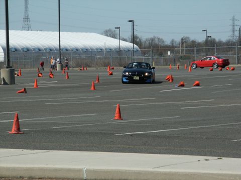 2001 Mercury Grand Marquis - A black convertible navigates an autocross course, with a red sports car visible in the distance.