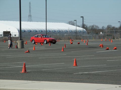 2001 Mercury Grand Marquis - Red BMW E46 coupe navigates an autocross course marked by orange traffic cones.