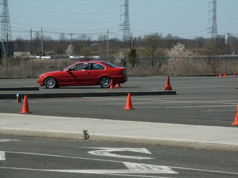 2001 Mercury Grand Marquis - A red coupe navigates an autocross course marked by orange cones.
