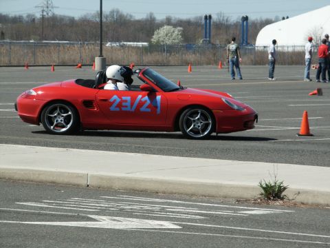 2001 Mercury Grand Marquis - A red convertible sports car with blue numbers 23/21 on its side is seen on a track during an event.