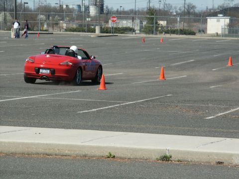 2001 Mercury Grand Marquis - A red convertible navigates an autocross course marked by orange cones in a large parking lot.