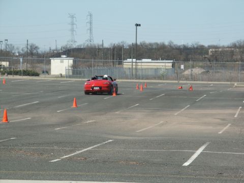 2001 Mercury Grand Marquis - A red convertible navigates a course marked by orange cones in an asphalt lot.
