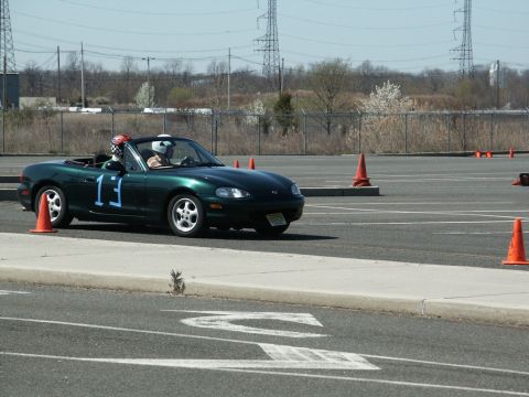 2001 Mercury Grand Marquis - Green convertible sports car with racing number 13 on the door navigates a course marked by orange cones.