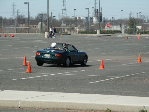 2001 Mercury Grand Marquis - A green convertible sports car is seen from the rear on an autocross course with orange cones.