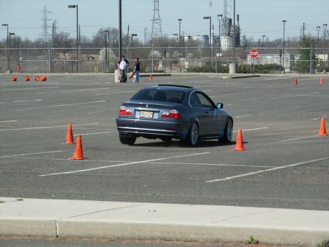 2001 Mercury Grand Marquis - BMW 3 Series coupe driving through an autocross course in a large parking lot.