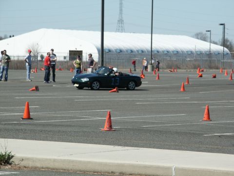 2001 Mercury Grand Marquis - A dark convertible sports car navigates an autocross course marked by orange cones.