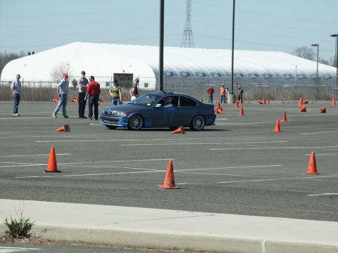 2001 Mercury Grand Marquis - BMW 3 Series coupe participating in an autocross event with cones set up on asphalt.