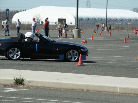 2001 Mercury Grand Marquis - A driver in a helmet navigates a course marked by orange cones on a sunny day.