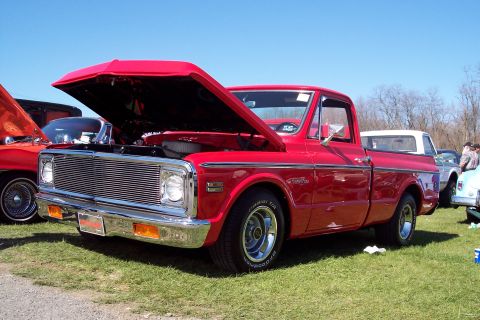 2001 Ford Crown Victoria - Red pickup truck from the 1970s with its hood open at an outdoor car show.