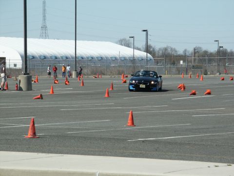 2001 Mercury Grand Marquis - A black BMW Z4 convertible navigates a course marked by orange traffic cones on a paved lot.