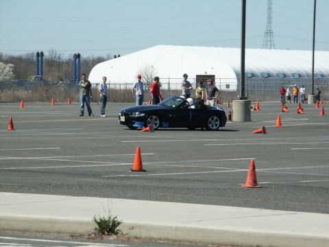 2001 Mercury Grand Marquis - A black convertible sports car navigates a course marked by orange cones during an event.
