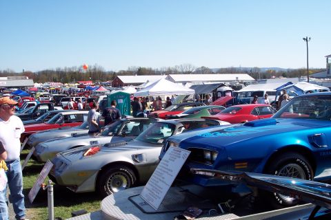 2001 Ford Crown Victoria - Cars are displayed at an outdoor event under a clear blue sky, with tents and vendors in the background.