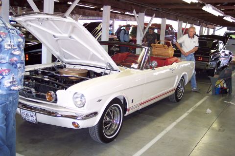 2001 Ford Crown Victoria - White 1965 Ford Mustang convertible on display with its hood open, showing the engine and interior.