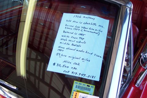 2001 Ford Crown Victoria - A handwritten sign details the history and mileage of a 1966 Ford Mustang, including its restoration and sale price.