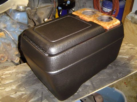 1978 Ford Bronco - A close-up view of a vehicle's aftermarket center console, a textured black finish and dual cup holders.