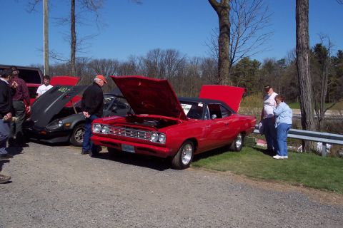2001 Ford Crown Victoria - A red 1969 Plymouth Road Runner is displayed with its hood open at an outdoor car show.