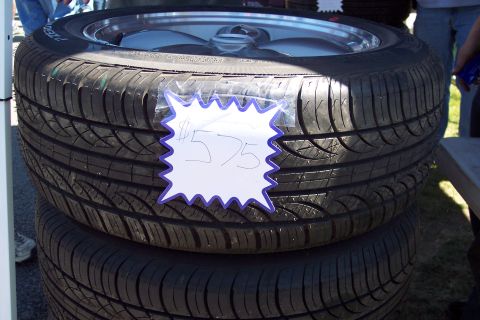2001 Ford Crown Victoria - A close-up view of two stacked tires, one displaying a handwritten price tag.