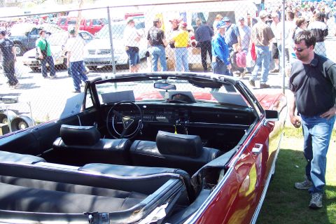2001 Ford Crown Victoria - Interior view of a red convertible with a man standing nearby at an outdoor event.