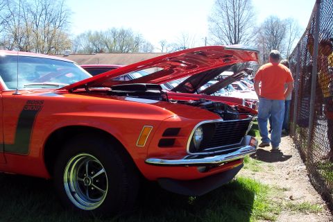 2001 Ford Crown Victoria - A classic orange Ford Mustang Boss 302 is displayed with its hood open at an outdoor event.