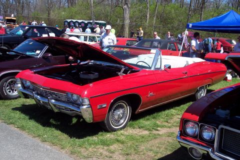 2001 Ford Crown Victoria - A red convertible, likely a 1968 model, is displayed with its hood open at an outdoor car show.