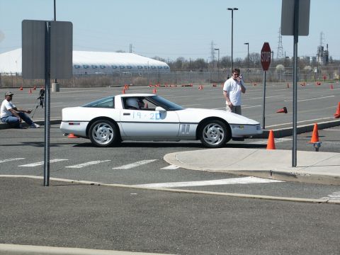 2001 Mercury Grand Marquis - A white Chevrolet Corvette is seen on a closed course with orange cones marking a path.