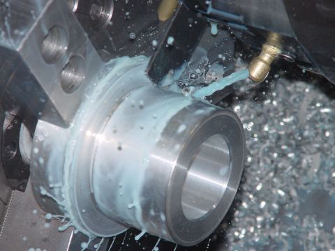 1979 Ford Bronco - Machining a metal part on a lathe with coolant applied.