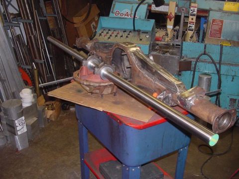 1979 Ford Bronco - A rear axle housing assembly with shafts is shown on a utility cart in a workshop setting.
