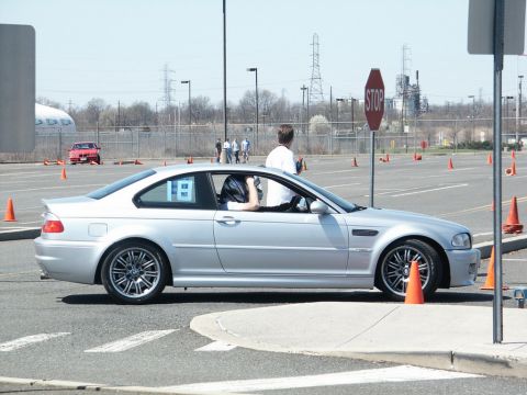 2001 Mercury Grand Marquis - A silver BMW M3 E46 is seen on a closed course, navigating through a series of orange cones during an event.