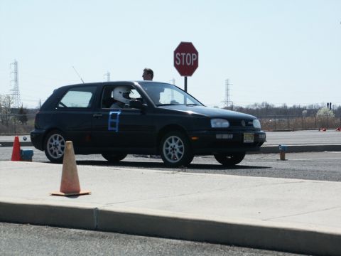 2001 Mercury Grand Marquis - A black Volkswagen Golf GTI with racing number 8 on the door is seen on a track with cones and a stop sign.
