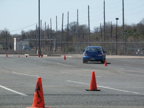 2001 Mercury Grand Marquis - A blue sedan drives through an autocross course with orange cones set up on a paved lot.