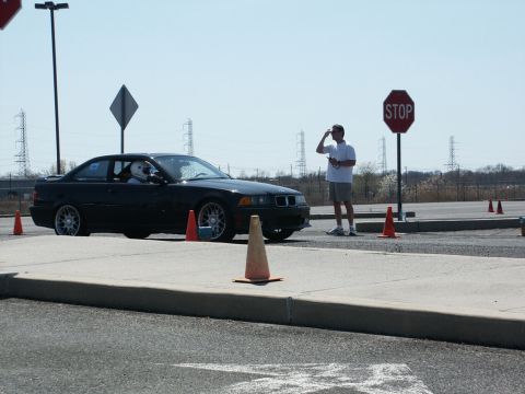 2001 Mercury Grand Marquis - Driver in helmet in black BMW E36 M3 at an autocross event with cones and a stop sign.