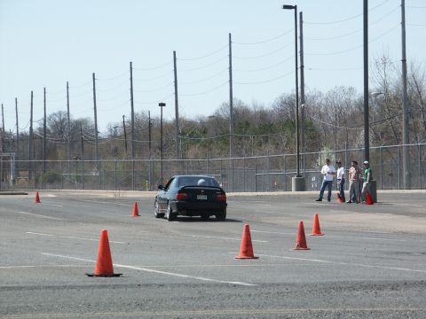 2001 Mercury Grand Marquis - A black BMW M3 navigates a course marked by orange cones on a sunny day.