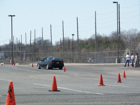 2001 Mercury Grand Marquis - A black sedan drives through a course marked by orange cones on a sunny day.