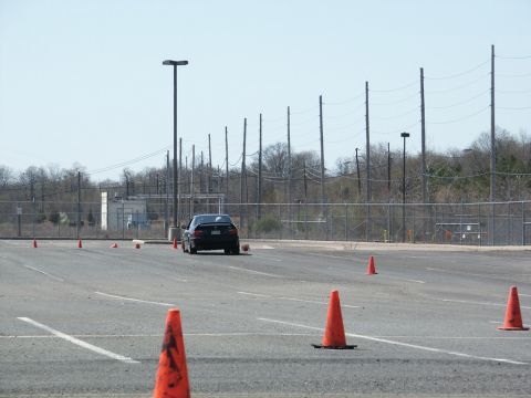 2001 Mercury Grand Marquis - A black sedan navigates a course marked by orange cones on a paved lot.
