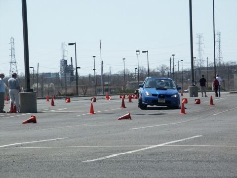 2001 Mercury Grand Marquis - Blue Subaru WRX STI on an autocross course with industrial background.