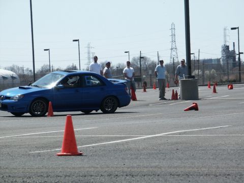 2001 Mercury Grand Marquis - A blue Subaru Impreza WRX sedan is seen on an autocross course with orange cones marking the path.