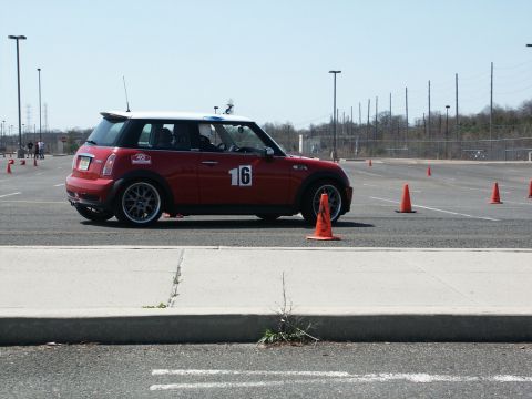 2001 Mercury Grand Marquis - A red Mini Cooper, marked with the number 16, participates in an autocross event on a sunny day.