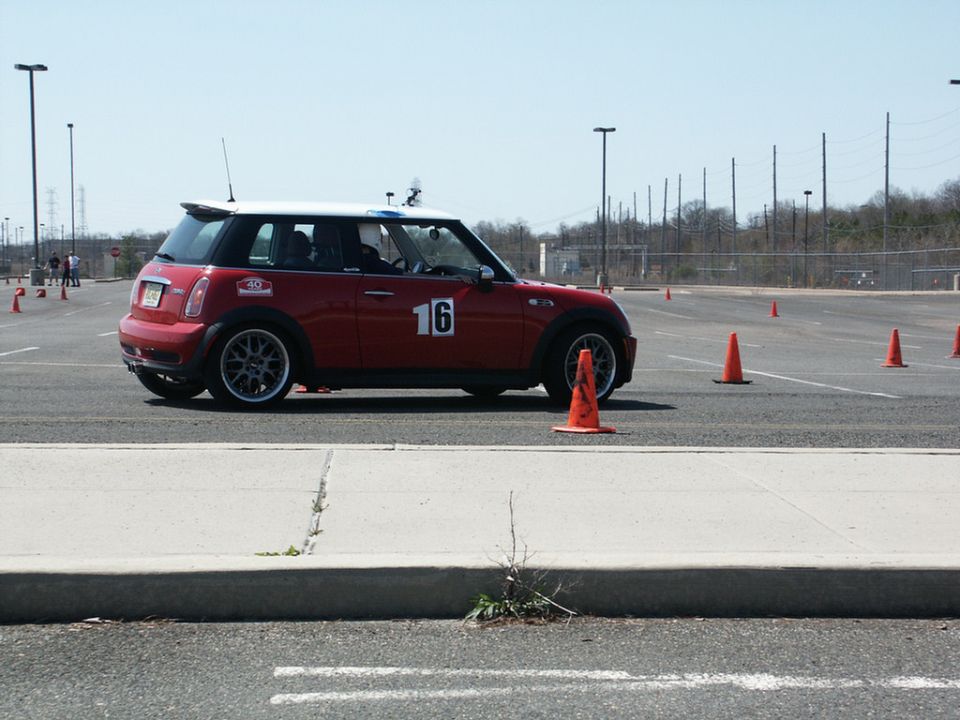 Red Mini Cooper with number 16 on the door navigating an autocross course