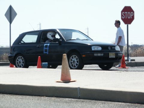 2001 Mercury Grand Marquis - A black Volkswagen Golf GTI is on a track with cones and a stop sign visible.
