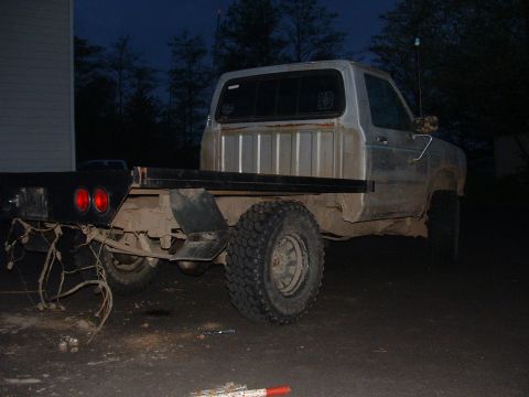1983 Ford Ranger - A silver flatbed truck is viewed from the rear, showing its modified bed and exposed wiring.